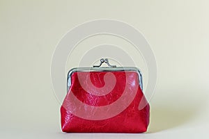 A closed red coin purse on a light beige background with a place to copy.