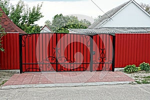 Closed red gates and metal fence in the street