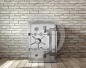 Closed and reliable steel safe in front of brickwall,