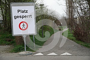 Closed school compound due to closed schools with coronavirus COVID-19  shield in German saying `place is blocked` meaning `no ent photo