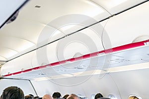 Closed shelves for hand luggage at airplane. Aircraft interior during regional flight