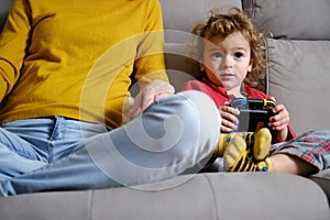 Closed shot of a child playing video games with his mother