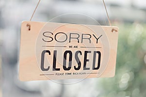 Closed sign hanging front of cafe mirror door