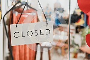 Closed sign hanging up on glass door , in front of fashion clothing store in Bangkok