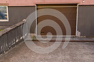 Closed with sliding door entrance to parking lot in basement of apartment building. Slope of floor is made of concrete screed.