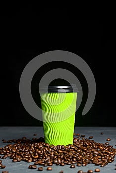 Closed take-out coffee with cup holder. One green cup with coffee beans over black background.