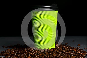 Closed take-out coffee with cup holder. One green cup with coffee beans over black background.