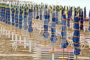 Closed umbrellas in line on the beach