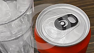 Closed up of Aluminum red soda can with a glass of ice cubes