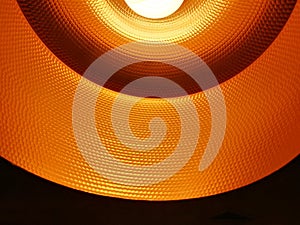 Closed up of black orange ceiling lamp with energy saving fluorescent light bulb