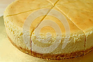 Closed up a delectable creamy yellow color whole baked cheesecake
