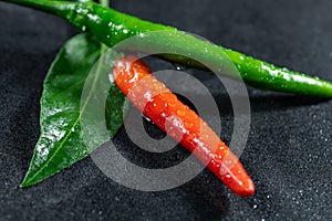 Closed up of Green chili on top of red chili with leaf