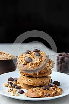 Closed up heap of Chocolate chips cookies in white plate on black background.