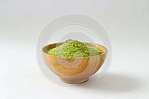 Closed up isolate heap of extract Green Tea powder in wooden bo