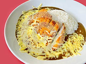 Closed up of Japanese curry rice with fried pork and mozzarella cheese, serving on white plate, Japanese traditional food