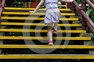 Closed up little girl climbing up stairs outdoors