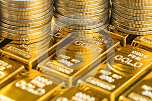 closed up shot of shiny gold bars with stack of coins as business or financial investment and wealth concept