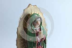 Small Figure Statue of Blessed Virgin Mary in Roman Catholic Church on white background.