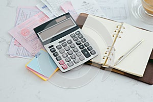 Closed up and soft focus on pen laying on paperwork with calculator for summary income or profit at office desk