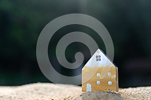Closed up tiny home model on green grass with sunlight background