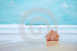 Closed up tiny home models on sand with sunlight and beach