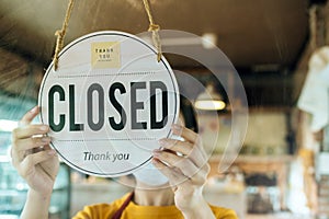 Closed. waitress woman wearing protection face mask turning open sign board on glass door in modern cafe coffee shop, cafe restaur