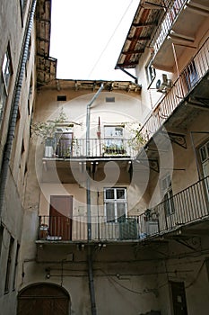 Closed well-type yard of the old house, with the entrance doors of the apartments overlooking the common balconies