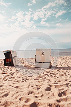 Closed wicker beach chairs on empty sandy beach at Baltic Sea