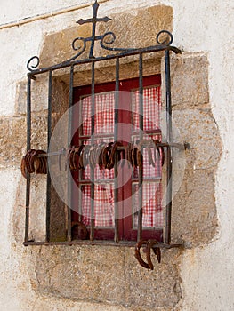 Closed window with iron grills and horseshoes. Basque Country.