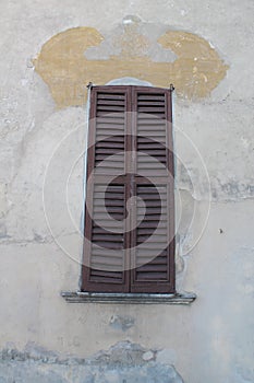 Closed window with old wood shutters on a white background