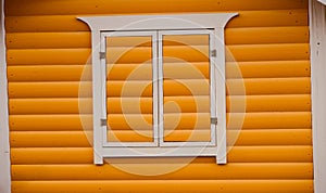 Closed window of a yellowish wooden building