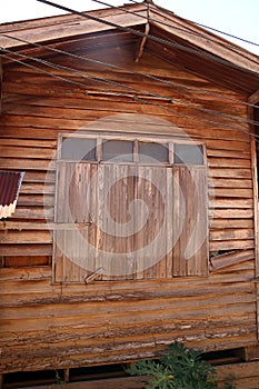 Closed wood window of old wooden house wall.