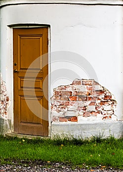 Closed wooden door and peeled facade