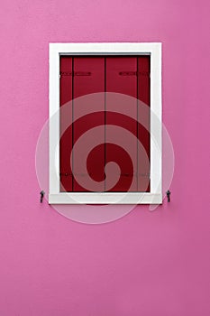 Closed wooden shutter on pink background