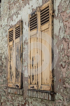 a closed wooden shutter on the wall of a house