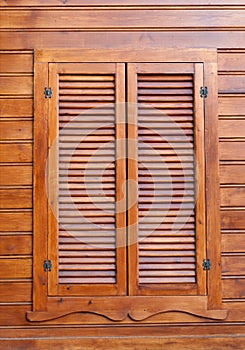 Closed wooden shutters on a wooden panneled wall