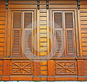 Closed wooden shutters on a wooden panneled wall