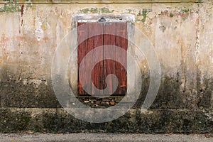 Closed wooden window shutters on a cement wall