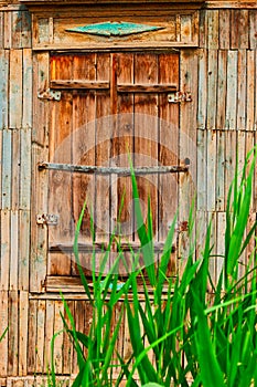 Closed wooden window of slum house front view, shanties detail photo