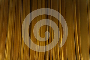 Closed yellow curtain background spotlight beam illuminated. Theatrical drapes