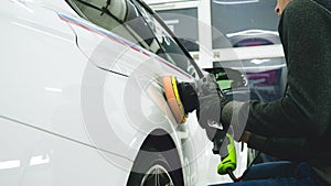 Closely shown as a professional worker polishes the transport car body using a polishing tool machine. Concept from: Auto serv