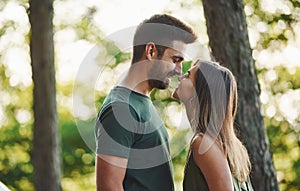 Closeness of people. Beautiful young couple have a good time in the forest at daytime