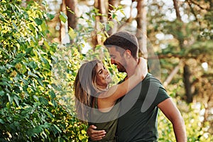 Closeness of people. Beautiful young couple have a good time in the forest at daytime