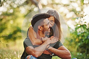 Closeness of people. Beautiful young couple have a good time in the forest at daytime