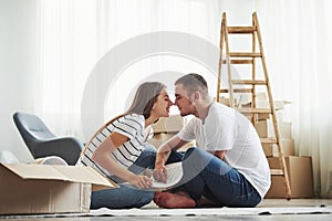 Closeness of the people. Cheerful young couple in their new apartment. Conception of moving