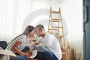 Closeness of the people. Cheerful young couple in their new apartment. Conception of moving