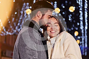 Closeness of the people. Happy young couple celebrating New year outdoors on the street