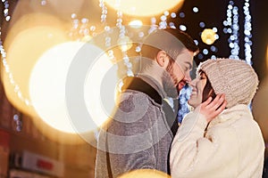 Closeness of the people. Happy young couple celebrating New year outdoors on the street