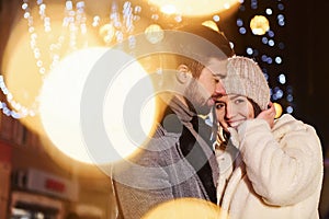 Closeness of the people. Happy young couple celebrating New year outdoors on the street