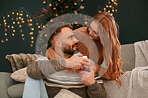 Closeness of the people. Lovely young couple are celebrating New Year at home